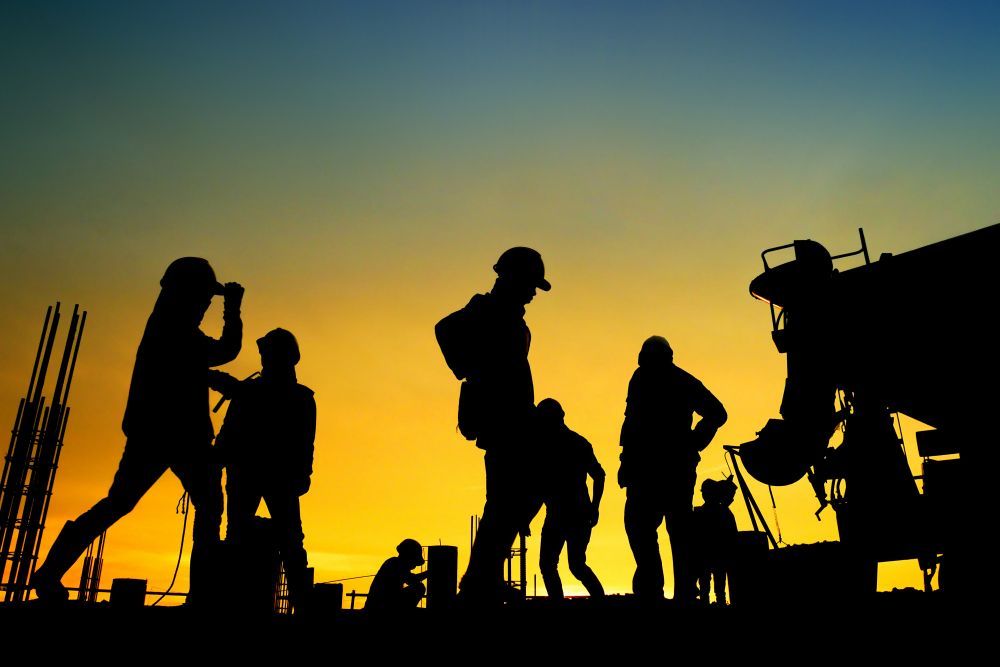 construction workers on a site as the sun sets
